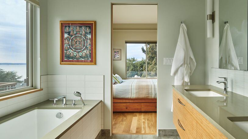 The natural textures in the master bathroom, with in-floor heating, a spacious soaking tub and lots of light, “feel comfortable and calm,” homeowner Olivier Carduner says. “The stone in the shower (out of view) builds on the whole connection with nature. The tiles feel a little like water flowing.” (Benjamin Benschneider/Seattle Times/TNS)