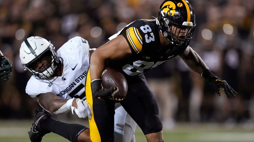 Iowa tight end Erick All (83) breaks a tackle by Michigan State linebacker Jordan Hall (5) during a 13-yard touchdown reception in the first half of an NCAA college football game, Saturday, Sept. 30, 2023, in Iowa City, Iowa. (AP Photo/Charlie Neibergall)
