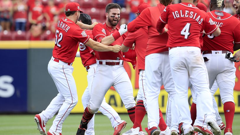 CINCINNATI, OHIO - JUNE 19: Jesse Winker #33 (third from left facing camera) of the Cincinnati Reds celebrates with teammates after hitting a game winning RBI single in the 9th inning against the Houston Astros at Great American Ball Park on June 19, 2019 in Cincinnati, Ohio. (Photo by Andy Lyons/Getty Images)
