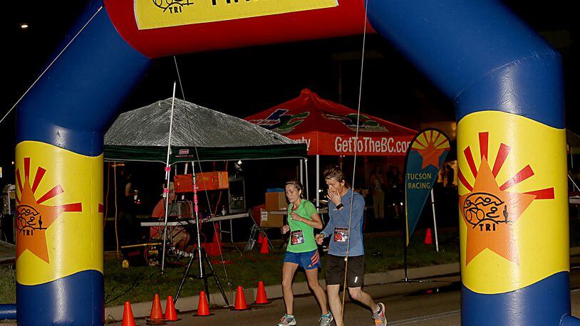 Kelsey Kennedy, from Edgewood, Ky., and Trent Turner, from Butler, Ky., complete the Midnight Madness Half Marathon last year in Hamilton. This year’s NightGlow Marathon will take place Sept. 2.
