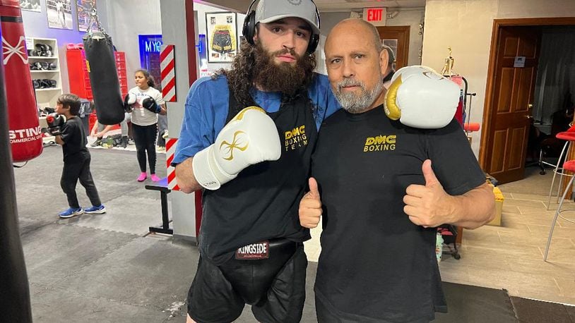 Andrew Zammit (known in gym as Jrue King) with his trainer, Daniel Meza Cuadra, at the DMC Boxing Academy in Centerville on Wednesday night. Zammit has qualified to fight in the Olympic Trials in Louisiana in early December. Tom Archdeacon/CONTRIBUTED