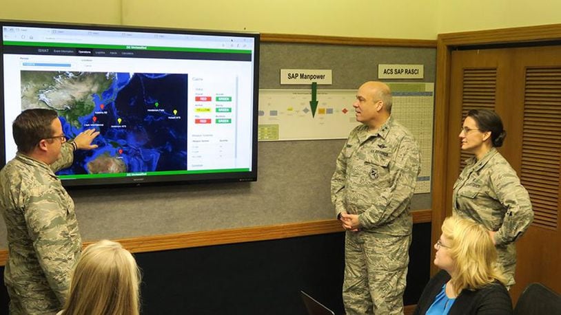 (From left to right) Maj. Nick Kirsch, Maj. Gen. Michael Brewer and Col. Francesca Bartholomew, of Air Force Materiel Command, review an analysis from an Integrated Sustainment Wargaming Analysis Toolkit (ISWAT) scenario. Frontier Technology helped develop the ISWAT technology. (U.S. Air Force photo)