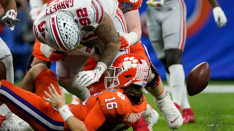 Ohio State defensive tackle Haskell Garrett force a fumble by Clemson quarterback Trevor Lawrence during the second half of the Sugar Bowl NCAA college football game Friday, Jan. 1, 2021, in New Orleans. (AP Photo/John Bazemore)