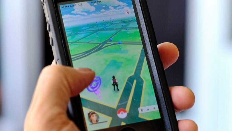 Pokemon Go is displayed on a cell phone in Los Angeles on Friday, July 8, 2016. Just days after being made available in the U.S., the mobile game Pokemon Go has jumped to become the top-grossing app in the App Store. And players have reported wiping out in a variety of ways as they wander the real world, eyes glued to their smartphone screens, in search of digital monsters. (AP Photo/Richard Vogel)