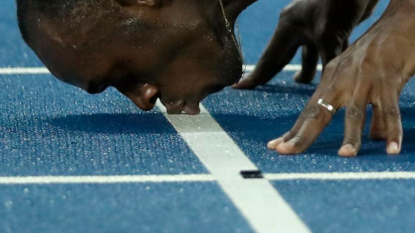 Usain Bolt from Jamaica kisses the track, after crossing the line to win the gold medal in the men's 200-meter final, during the athletics competitions of the 2016 Summer Olympics at the Olympic stadium in Rio de Janeiro, Brazil, Thursday, Aug. 18, 2016. (AP Photo/Matt Dunham)