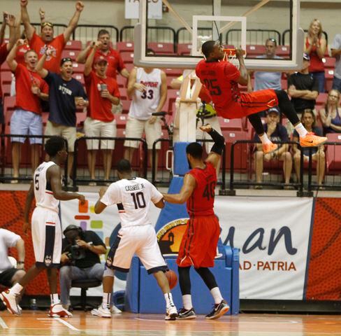 Dayton forward Kendall Pollard dunks and pull himself up on the rim against Connecticut in the semifinals of the Puerto Rico Tip-Off on Friday, Nov. 21, 2014, at Coliseo Roberto Clemente in San Juan, P.R. Pollard was called for a technical foul. David Jablonski/Staff