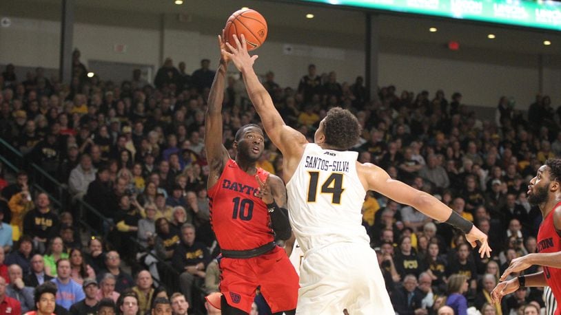 Dayton’s Jalen Crutcher throws a pass to Josh Cunningham but commits a turnover in the final minutes against Virginia Commonwealth on Wednesday, Jan. 16, 2019, at the Siegel Center in Richmond, Va.