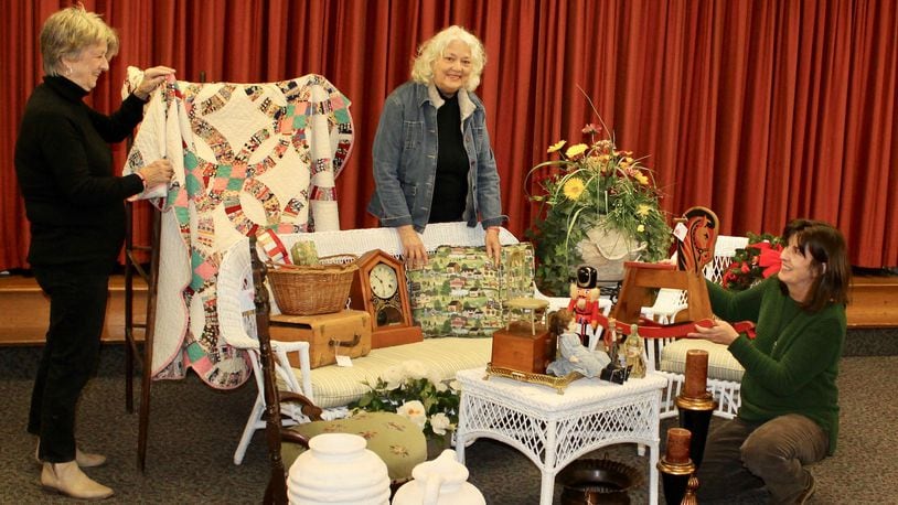 Volunteer Callie Johnson (from left), event chair Carolyn Wimer and volunteer Kerri Miles with some of the auction, vintage and other items that will be for sale during the Fairmont Presbyterian Church Arts, Crafts and Antiques Show. CONTRIBUTED