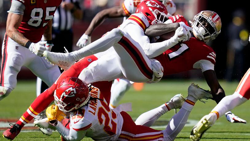 San Francisco 49ers wide receiver Brandon Aiyuk, right, is tackled by Kansas City Chiefs safety Juan Thornhill, second from top, and cornerback Chris Lammons (29) during the first half of an NFL football game in Santa Clara, Calif., Sunday, Oct. 23, 2022. (AP Photo/Godofredo A. Vásquez)