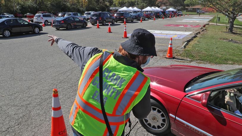 Kyle Trout, communications coordinator for the Clark County Combined Health District, directs traffic during a free drive-thru COVID-19 testing clinic Oct. 16, 2020, in the parking lot of Kenton Ridge High School. BILL LACKEY/STAFF