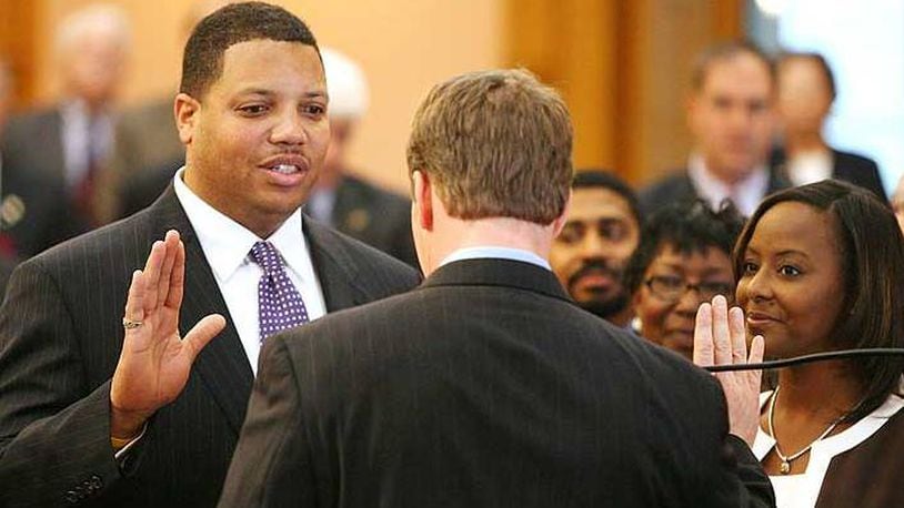 In this file photo: Clayton Luckie, D, 39th District, left, with his wife Lisa looking on, right, is sworn in by Speaker of the House Jon A. Husted Tuesday, Nov. 14, 2006, in Columbus, Ohio.