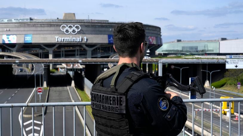 A gendarmes patrol in front of the Charles de Gaulle airport, terminal 1, where the olympic rings were installed, in Roissy-en-France, north of Paris, Tuesday, April 23, 2024 in Paris. (AP Photo/Thibault Camus)