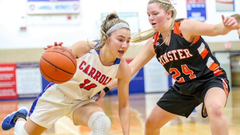 Carroll’s Ava Lickliter drives to the hoop against Minster’s Courtney Ernst during their game in Dayton on Sunday afternoon. Minster won 50-35. CONTRIBUTED PHOTO BY MICHAEL COOPER
