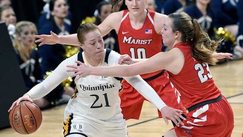 Quinnipiac forward Jen Fay (21) moves the ball against Marist's Maura Fitzpatrick (10) and Rebekah Hand (23) during the second half of an NCAA college basketball game in the championship of the Metro Atlantic Athletic Conference tournament Monday, March 5, 2018, in Albany, N.Y. Quinnipiac won the game 67-58. (AP Photo/Hans Pennink)