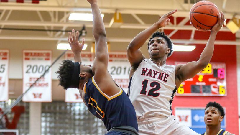 Wayne High School’s Ronnie Hampton drives to the hoop against Springfield’s Larry Stephens during their game on Friday night in Huber Heights. The Warriors won 75-72 in triple overtime. CONTRIBUTED PHOTO BY MICHAEL COOPER
