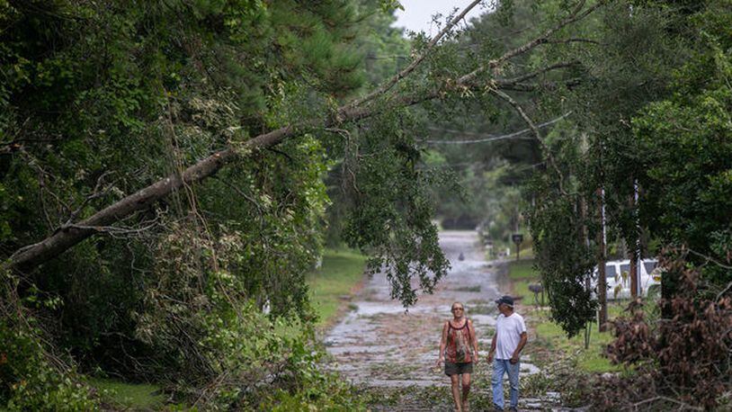 FILE PHOTO: Jack and Linda Hodgkiss look at a tree that fell across Bayshore Drive in Little River, S.C. A couple in Charleston said an island of trees floated past their house.