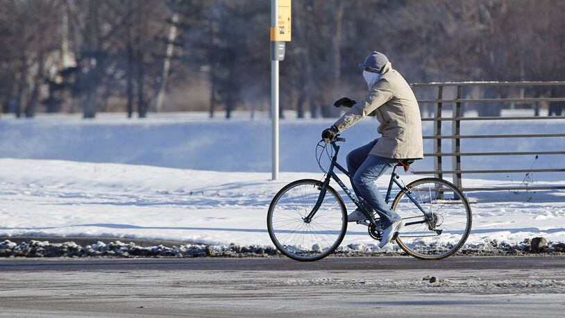 A bicyclist crosses the Stewart Street Bridge on Tuesday morning in sub-zero temperatures. TY GREENLEES / STAFF