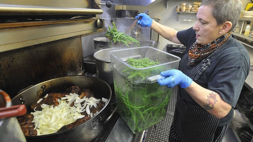 Elizabeth Liz Valenti, the head chef, at Wheat Penny Oven & Bar, on Wayne Ave. works nearly 15 hours a day preparing food for takeout orders through the day. MARSHALL GORBYSTAFF