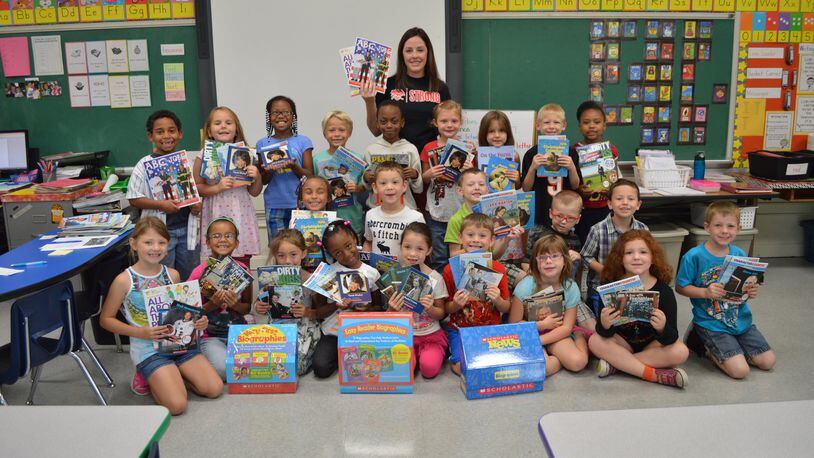 First-graders at CF Holliday school in West Carrollton show off their new books, purchased with grant money from the South Metro Chamber of Commerce. . CONTRIBUTED PHOTO