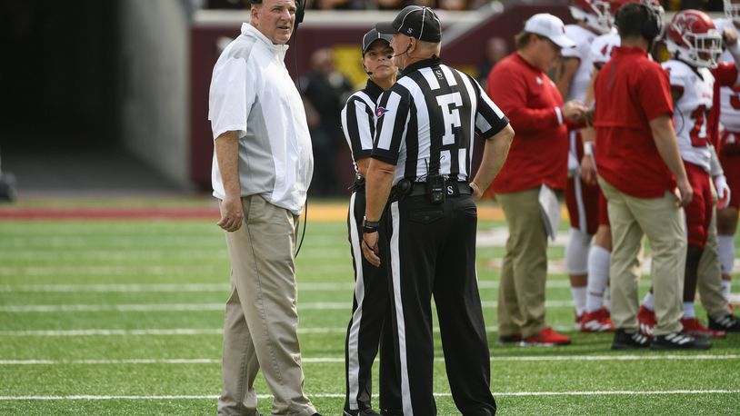Miami-Ohio head coach Chuck Martin, left, talks with the game officials during a break in the first half of an NCAA college football game against Minnesota Saturday, Sept. 11, 2021, in Minneapolis. Minnesota won 31-26. (AP Photo/Craig Lassig)