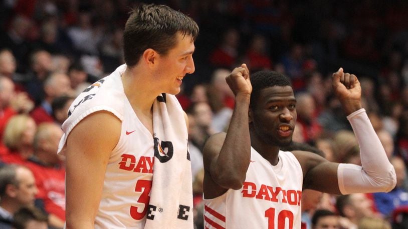 Dayton’s Ryan Mikesell, left, and Jalen Crutcher celebrate on the bench after a score against Detroit on Tuesday, Dec. 4, 2018, at UD Arena. David Jablonski/Staff