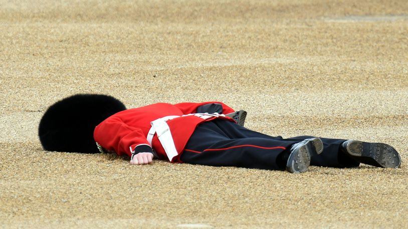 LONDON, ENGLAND - JUNE 11: A member of the Queens Guard collapses during the Trooping the Colour, this year marking the Queen's 90th birthday at The Mall on June 11, 2016 in London, England. The ceremony is Queen Elizabeth II's annual birthday parade and dates back to the time of Charles II in the 17th Century when the Colours of a regiment were used as a rallying point in battle. (Photo by Stuart C. Wilson/Getty Images)