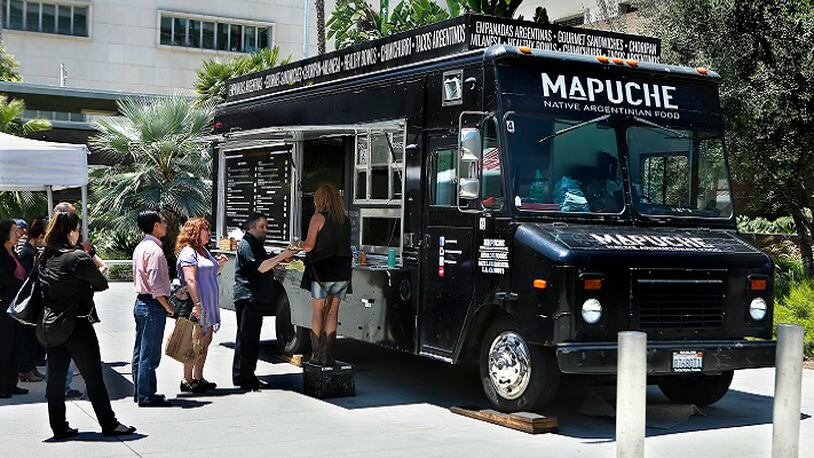 Customers wait in line at Mapuche, an Argentinian food truck, parked at Grand Park in downtown Los Angeles on July 26, 2017. (Mel Melcon/Los Angeles Times/TNS)