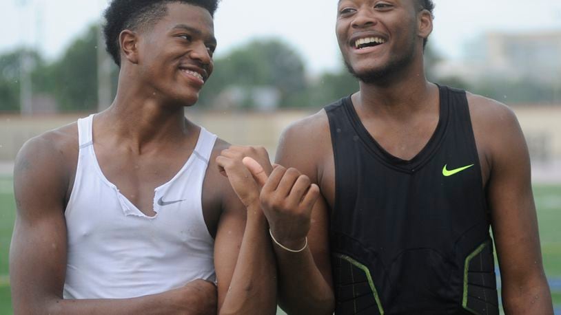 Joseph Scates of Dunbar (left) gets an approval rating from big brother and teammate Terrance Landers. A 7-on-7 high school football passing tournament was held at Dayton’s Welcome Stadium on Friday, July 10, 2015. MARC PENDLETON / STAFF