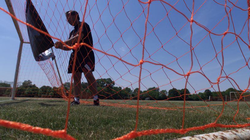 In 2005, Warrior Soccer Club coach George Dowling puts up sponsor adidas's sign on a goal net at Thomas Cloud Park for the adidas Warrior Classic Tournament. (Courtesy/Jim Witmer)