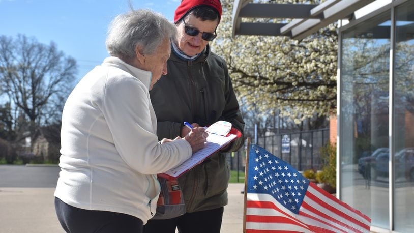 Janice James, a volunteer with Citizens Not Politicians, collects signatures outside of a polling place in Kettering for a constitutional amendment that supporters say will get rid of gerrymandering in the drawing of political maps. CORNELIUS FROLIK / STAFF