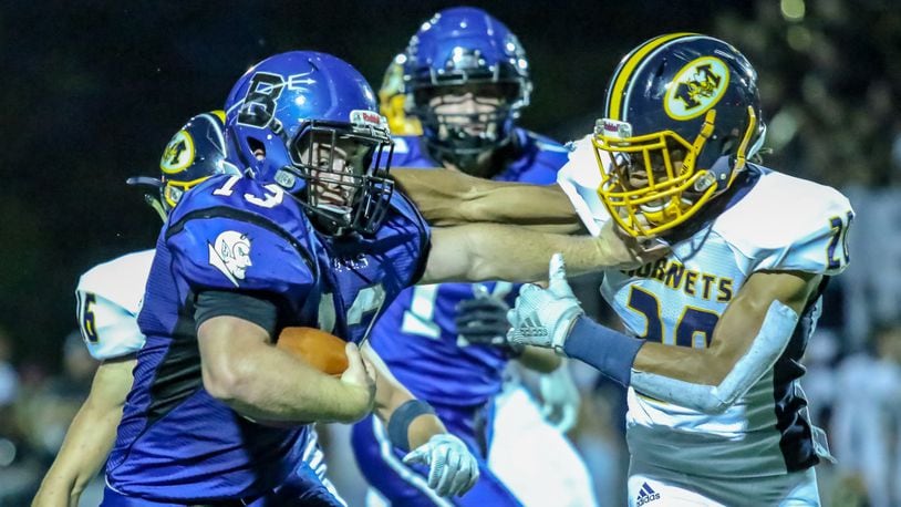 Brookville High School running back Connor Michael stiff arm’s Monroe’s TeJean Rice during their game on Thursday night at Brookville Stadium. The Blue Devils won 31-21. CONTRIBUTED PHOTO BY MICHAEL COOPER