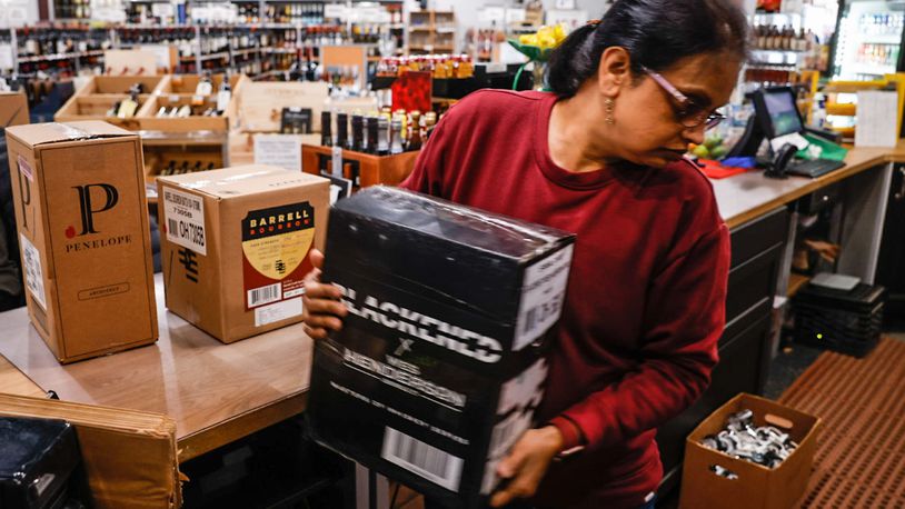 Vaishali Patel, co-owner of Centerville Liquor & Wine on South Main Street in Centerville, moves boxes of allocated bourbon Friday, Feb. 24, 2023. Total sales of liquor increased in Ohio in 2022 by nearly 1%, while the amount of gallons sold decreased by nearly 1.8%. JIM NOELKER/STAFF