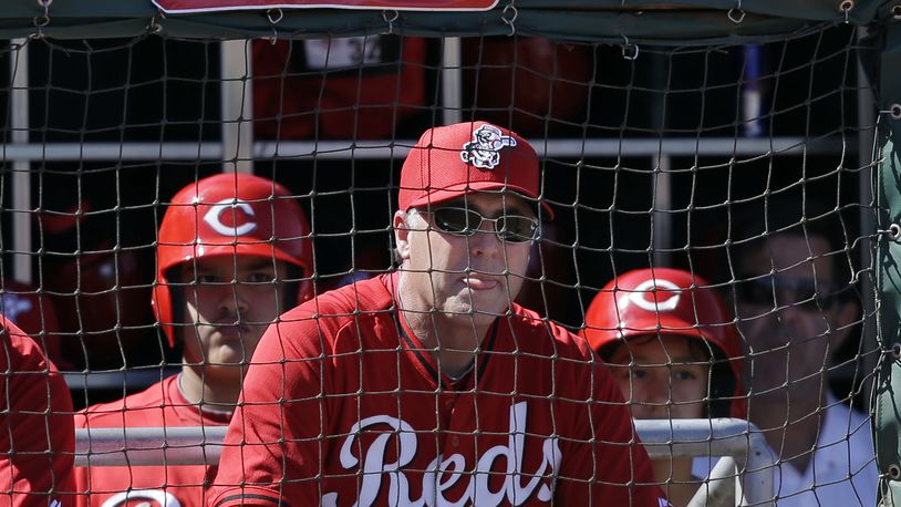 Cincinnati Reds manager Bryan Price, center, watches from the dugout in the second inning of a spring training exhibition baseball game against the Chicago Cubs Saturday, March 8, 2014, in Goodyear, Ariz. (AP Photo/Mark Duncan)