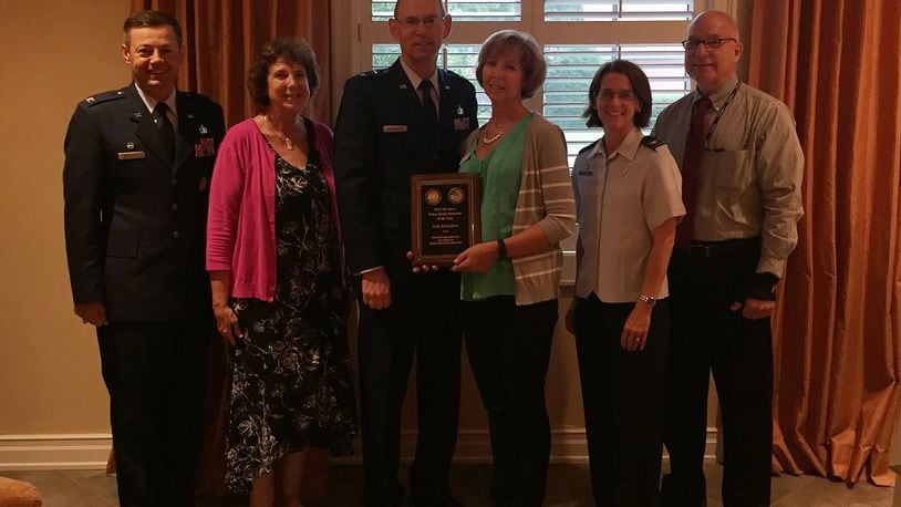 Joining 2017 Air Force Fisher House Volunteer of the Year Dede Richardson (center) Aug. 7 to celebrate her accomplishment were (left to right): Col. Bradley McDonald, 88th Air Base Wing commander; Karen Healea, Fisher Houses manager; Maj. Gen. Duke Richardson, Air Force program executive officer for Presidential Airlift Recapitalization, Air Force Life Cycle Management Center; Col. Shari Silverman, 88th Medical Group commander; and Dan Druzbacky, 88 MDG compassionate care manager. The award ceremony was held at the Fisher House II, one of two, side-by-side compassionate comfort care facilities at Wright-Patterson Air Force Base. (Skywrighter photo/Amy Rollins)