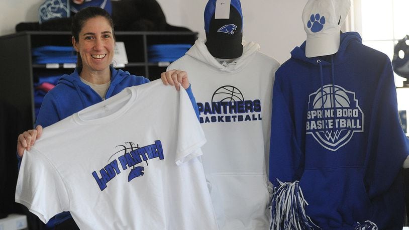 Deanna Bonilla. manager of the Fan Store in Springboro holds up a Lady Panther basketball T-shirt Wednesday, March 13, 2024. The Springboro Lady Panthers are playing in the state final four for the first time Friday, March 15, 2024. The Fan Store is located at 205 N. Main Street. MARSHALL GORBY\STAFF