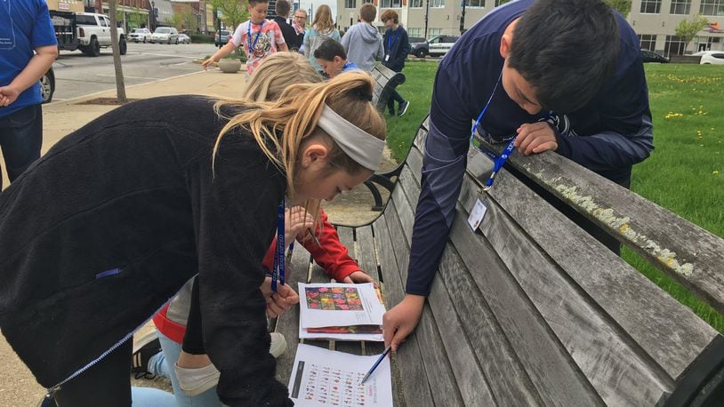 Xenia fifth-graders, from left, Nadia Lewis, Maddi Janowiecki and Cory Pham look at possible flowers to include in their adoption of a flower pot and landscape island in the downtown area as part of the city’s Bloom with Xenia program. RICHARD WILSON/STAFF