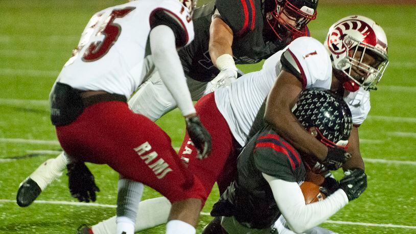 Trotwood’s defense swarms a ball carrier during its Division III state semifinal against Columbus Bishop Hartley on Friday at London High School. Jeff Gilbert/CONTRIBUTED