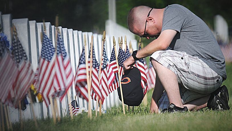 Donald King, of Piqua, pays his respects to his father, a Korean war veteran at the National Cemetery in Dayton on Memorial Day. MARSHALL GORBY / STAFF