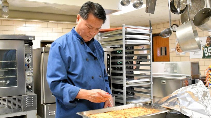 Art Chin, long-time chef and restaurant owner in Dayton and Tipp City, checks food being prepared as part of his new job in the kitchen at Broadway Elementary School in Tipp City. CONTRIBUTED