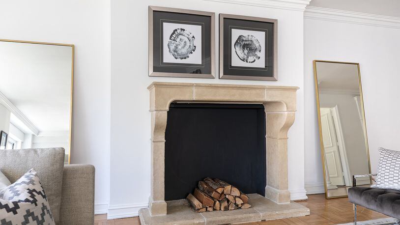 A pair of hung art pieces and leaning mirrors help fram a fireplace mantel. (Design Recipes)