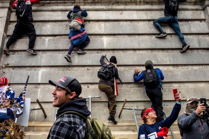 Protestors climb onto the Capitol in Washington on Wednesday, Jan. 6, 2021. (Jason Andrew/The New York Times)