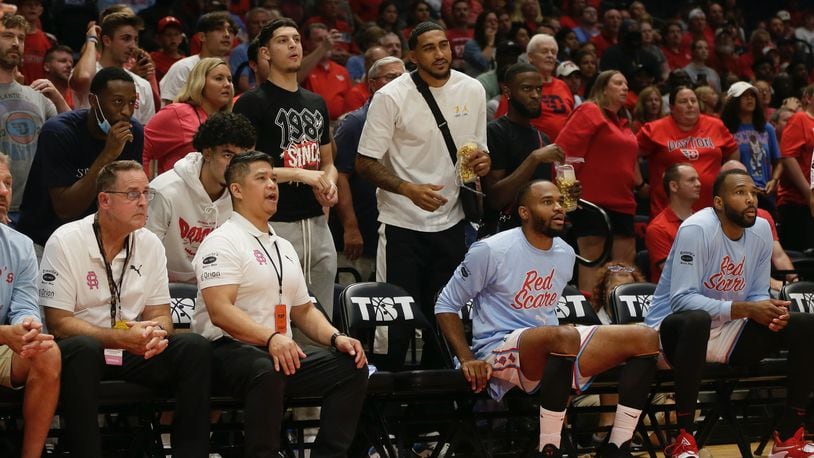 Obi Toppin and Jalen Crutcher and several current Dayton players watch from behind the bench during a game between the Red Scare and the Golden Eagles in The Basketball Tournament on Wednesday, July 27, 2022, at UD Arena. David Jablonski/Staff