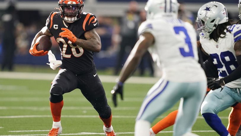 Cincinnati Bengals running back Joe Mixon (28) looks for running room as Dallas Cowboys cornerback Anthony Brown (3) close in during the second half of an NFL football game Sunday, Sept. 18, 2022, in Arlington, Tx. (AP Photo/Tony Gutierrez)