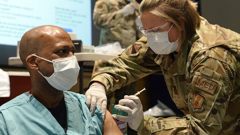 Maj. Kito Brooks, an 88th Medical Group podiatrist, receives the COVID-19 vaccine from Capt. Erica Eyer, an 88 MDG flight commander with the Aerospace Operational Medicine Clinic, at Wright-Patterson Air Force Base on Jan. 4. U.S. AIR FORCE PHOTO/TY GREENLEES