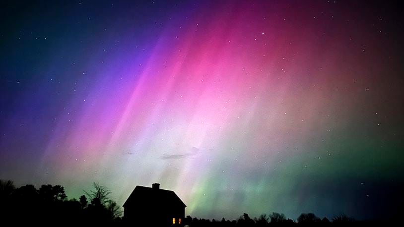 The northern lights flare in the sky over a farmhouse, late Friday, May 10, 2024, in Brunswick, Maine. (AP Photo/Robert F. Bukaty)