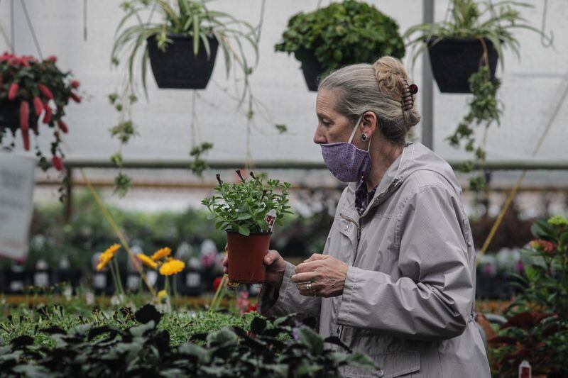 Cindy Jones of Troy sells plants at the Stockslagers greenhouse and garden center Tuesday morning.  Business has been booming this spring for the area garden center.  JIM NOELKER / STAFF