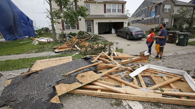Trotwood residents Ryan an Danielle Johnson rode out the tornado in the basement on Monday night and discovered half of their roof missing on Wolf Creek Run. TY GREENLEES / STAFF