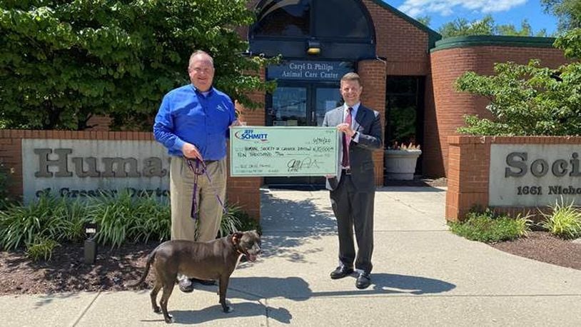 Jay Schmitt (right), President of Jeff Schmitt Auto Group presents a check for $10,000 to Brian Weltge (left), President and CEO of the Humane Society of Greater Dayton with Sadie (dog)