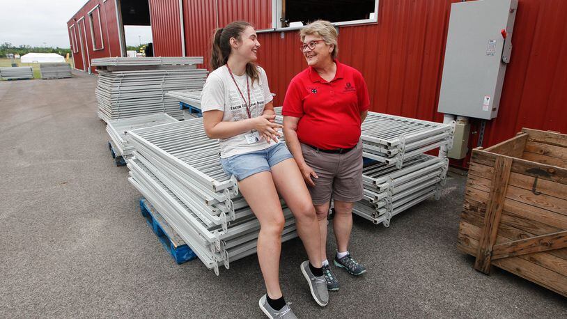 Charity Moore, a KNL 4-H Club member from Germantown, talks with Betty Wingerter, Ohio State University Extension 4-H youth development educator, during preparations Friday for the  Montgomery County Fair. CHRIS STEWART / STAFF