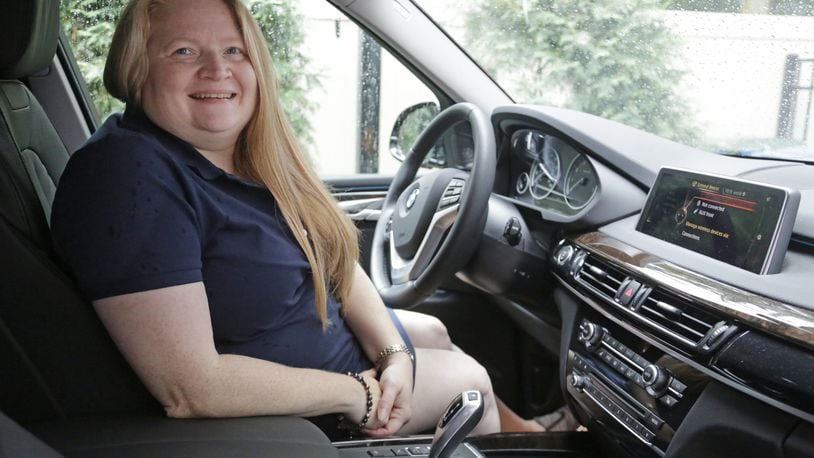 In this Aug. 24, 2016 photo, Kelly Dahle is shown with her BMW X5 in Downers Grove, Ill. Women are buying more luxury vehicles than ever before, thanks to growing earnings, better marketing and a richer mix of products designed to appeal to them. AP Photo/M. Spencer Green